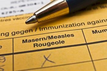 Kalender mit Eintrag Impfen! und darauf liegend ein Impfpass.